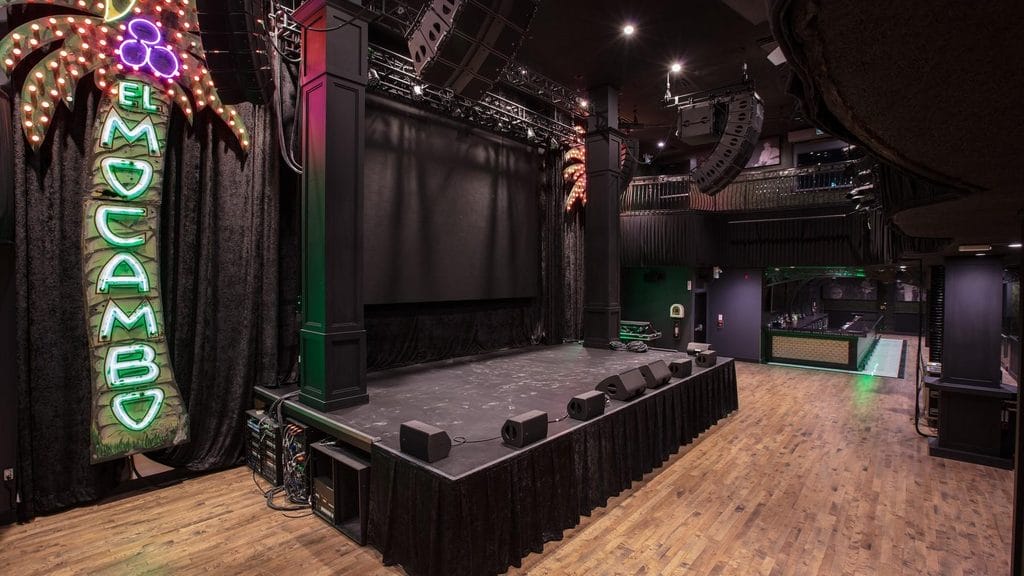 El Mocambo stage and neon palm sign inside the Toronto music venue A Spadina concert room under the neon palm